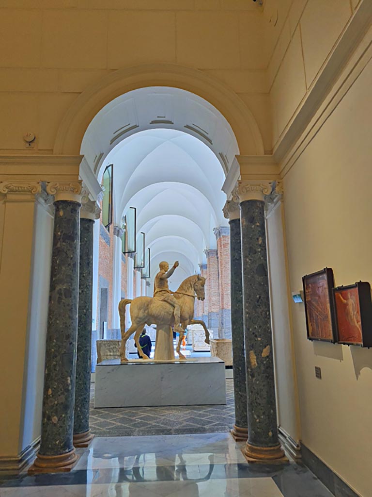 Naples Archaeological Museum, April 2023.
Looking out from Herculaneum Augusteum gallery display in “Campania Romana” gallery towards statue of Marcus Nonius Balbus.
Photo courtesy of Giuseppe Ciaramella.