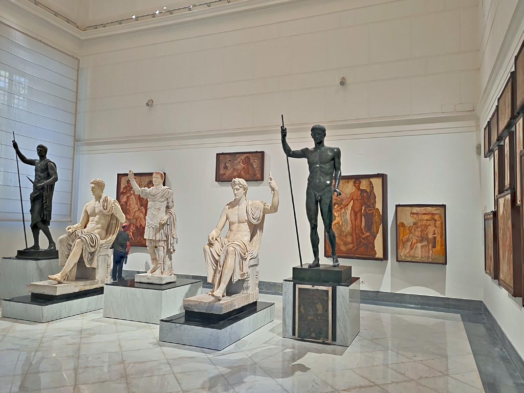 Herculaneum Augusteum. April 2023.
Looking across gallery towards statues on display in “Campania Romana” gallery in Naples Archaeological Museum.
(Note: the central statue of Titus has now been displayed). Photo courtesy of Giuseppe Ciaramella.