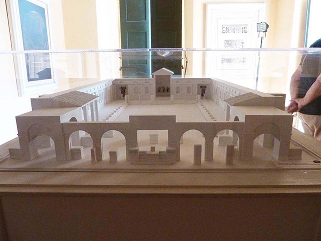 Herculaneum, Augusteum. September 2015. Augusteum model in Palazzo Reale showing locations of statues and paintings.
The Basilica was a large marble paved piazza, bordered by porticoes on all sides, and with a square exedra in the middle of the rear wall and an apse in each corner of the rear wall.
In the square exedra, at the rear centre in this model, were (left to right as seen here);
The statue of the sitting Augustus (MANN 6040)
The standing breast-plated Titus, centre, (MANN 6059)
The statue of the sitting Claudius (MANN 6056).
In the apse, left rear corner in this model, were the paintings of;
The liberation of the Athenian children at the hands of Theseus (MANN 9049)
The musical education of Olympus by Marsyas (MANN 9151)
In front of these was a bronze statue of Augustus (MANN 5595).
In the apse, right rear corner in this model, were the paintings of;
The recognising of Telephus by Hercules (MANN 9008).
The musical education of Achilles by Chiron (MANN 9109).
In front of these was a bronze statue of Claudius as a heroic nude (MANN 5593).
Somewhere in the decoration of the side porticoes belonged a fresco of the life and labours of Hercules, and a panel with Medea (MANN 8976)
In the left portico were a bronze statue of Livia and a bronze statue of a priestess of Isis.
Many other statues of the Julio-Claudian dynasty and the Flavian dynasty were also found.
There is still much debate about the actual locations of items found.