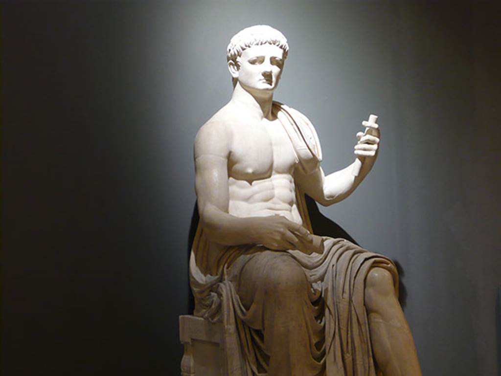 Herculaneum Augusteum. Square exedra. Statue of a seated Claudius.
Now in Naples Archaeological Museum. Inventory number 6056.
According to the information board on site, the statues were restored in the 19th century with the faces of Augustus and Claudius but were more probably Augustus and Vespasian.
Photo courtesy of Buzz Ferebee.