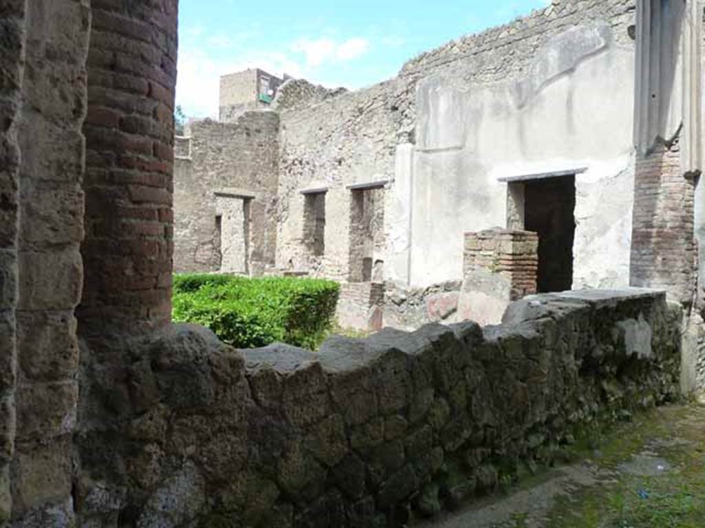 III.11 Herculaneum. May 2010. 
Looking north-west across the garden peristyle, towards doorway to room 17 in west wall, on left. 
The doorways to rooms 13 (with window) and 12 are on the north wall, centre and right.
Taken from doorway in north wall of room 8. 
For other photos of the peristyle area, see end of photos.
