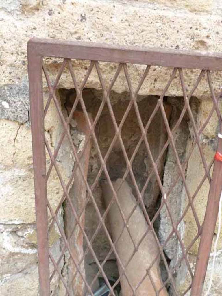 Ins. V. 6, Herculaneum. May 2010. Downpipe in wall of Bottega di Nettuno e Anfitrite on east side of Cardo IV Superiore.
