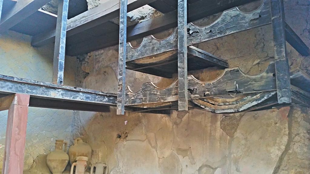 V.6 Herculaneum. Photo taken between October 2014 and November 2019. 
Shelving on south side of shop. Photo courtesy of Giuseppe Ciaramella.

