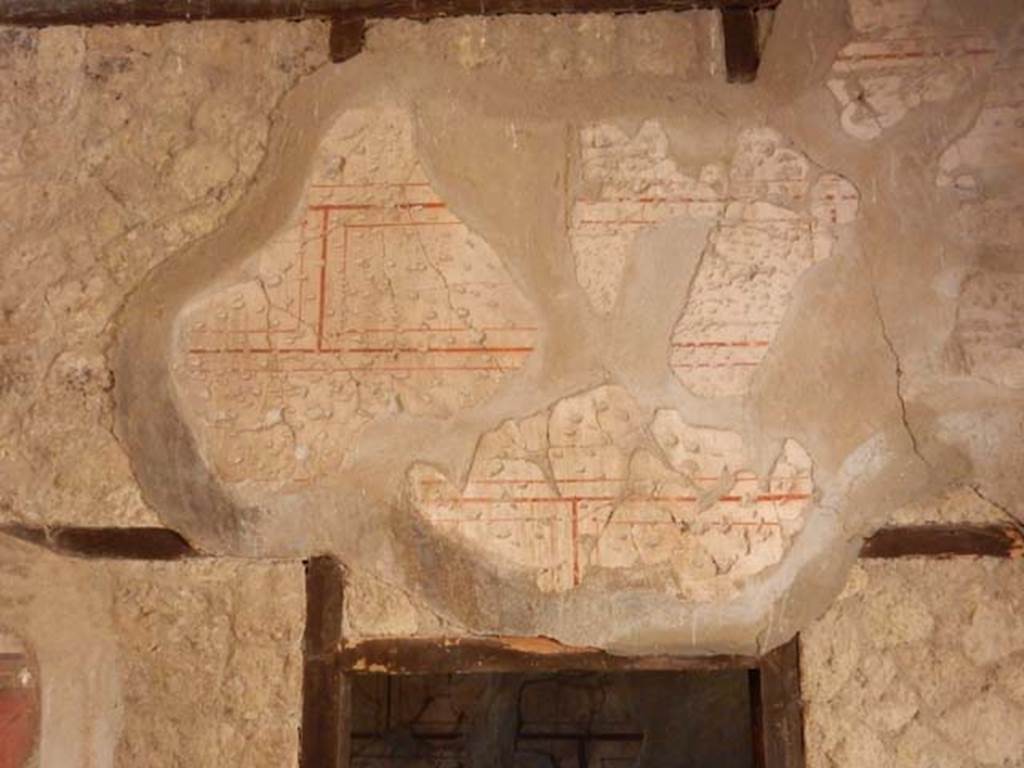 V.8 Herculaneum. May 2018. Room 1, remaining painted decoration above doorway to room 8, on south wall. 
Photo courtesy of Buzz Ferebee. 

