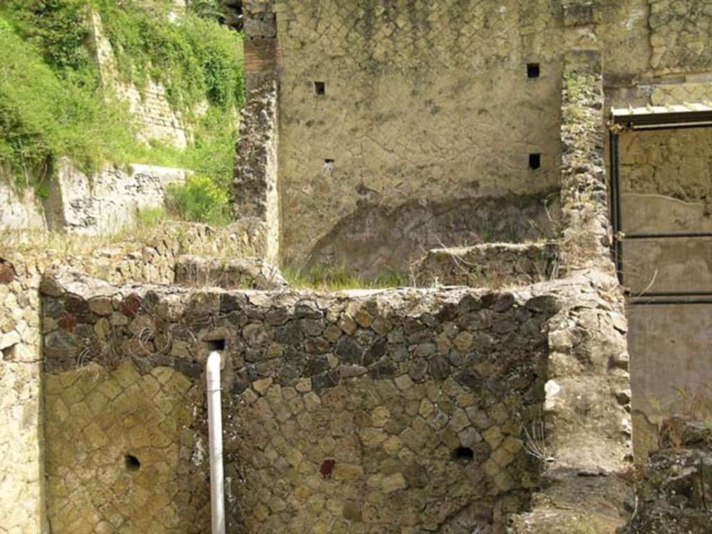 V.10/12, Herculaneum. May 2005. 
Looking east across upper areas, towards the higher west wall of shop at V.13, part of Casa del Bicentennario/House of Bicentenary.
In the lower part of the photo is the upper east wall of the shop-room at V.10, behind that are the upper walls of the entrance corridor of V.11, and then the upper east wall of shop at V.12 which is also a dividing wall of V.13/Casa del Bicentennario/House of Bicentenary 
Photo courtesy of Nicolas Monteix.

