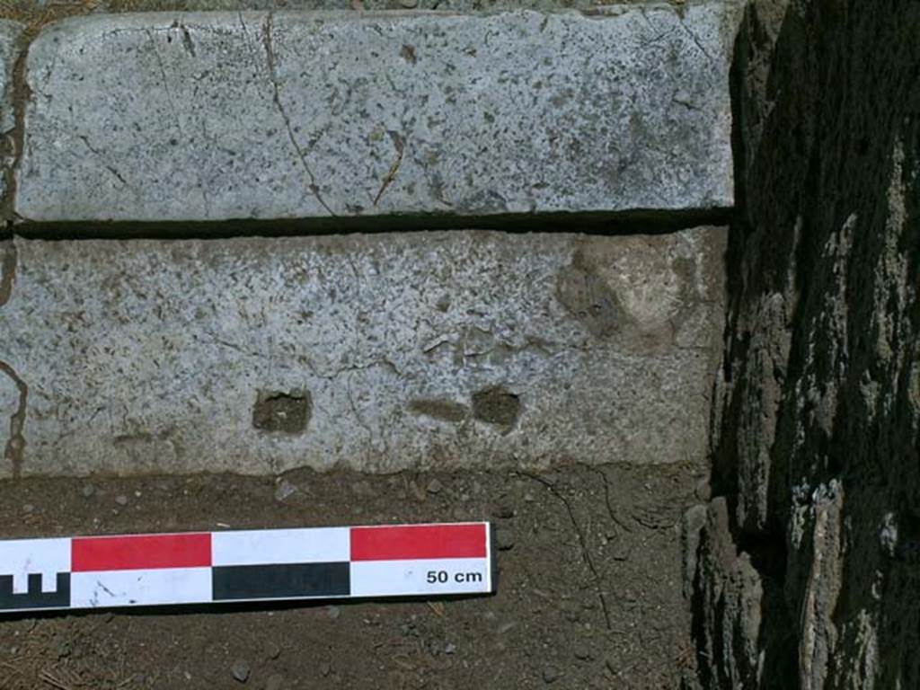 V.33, Herculaneum. May 2006. Detail from south end of entrance doorway threshold. 
Photo courtesy of Nicolas Monteix.

