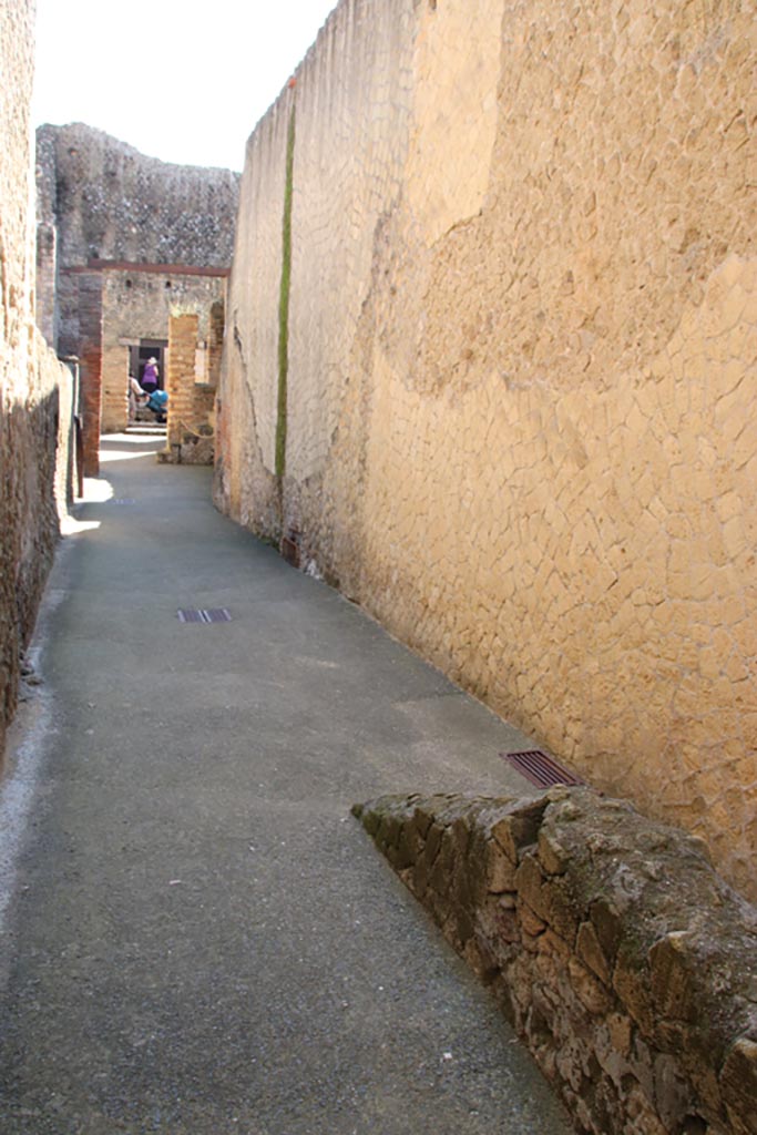 VI.10 Herculaneum. October 2022. 
Looking east along south wall of service corridor towards entrance on Cardo IV.
Photo courtesy of Klaus Heese.
