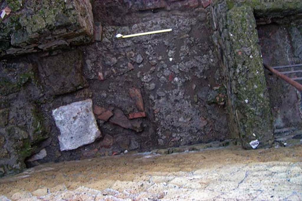 VI.30 Herculaneum. February 2003. Looking down against north wall to area between the vat/basin in north-west corner, on right, and hearth or bench in north-east corner, on left. 
Photo courtesy of Nicolas Monteix.
