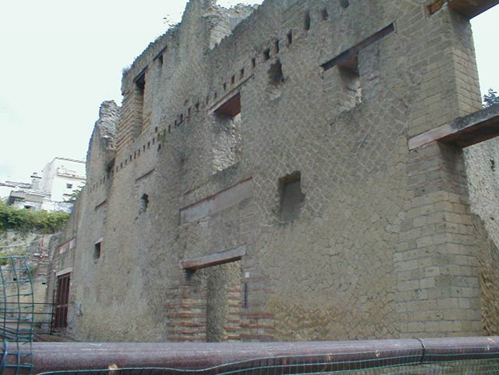 Ins. Orientalis II, 9, the bar (or wine shop) on left, 8 in centre, 7 on right. 
September 2004. Looking north-east. Regarding this area with its upper floors, Wallace-Hadrill wrote that usually the rooms on the first floor followed the same plan and layout as the ground floor; generally, the first-floor rooms are associated with the shop rooms below them. The second floor is the least well preserved, though the robust construction of the Palaestra exedra seem to have kept the central section more intact. It is here that we can trace the layout of at least one flat, with several rooms around an open space. The entrance seems to have been from the wooden balcony that ran across the façade. By a bit of luck, Maiuri’s men in 1933 failed to complete their clearance of these rooms, and it was possible in 2006 to excavate the final layers of the latrine of the apartment, together with its downpipe dropping down to the sewer below. To reach the latrine from the flat, you had to go out on the balcony.
See Wallace-Hadrill, A. (2011). Herculaneum, Past and Future. London, Frances Lincoln Ltd., (p.275)

