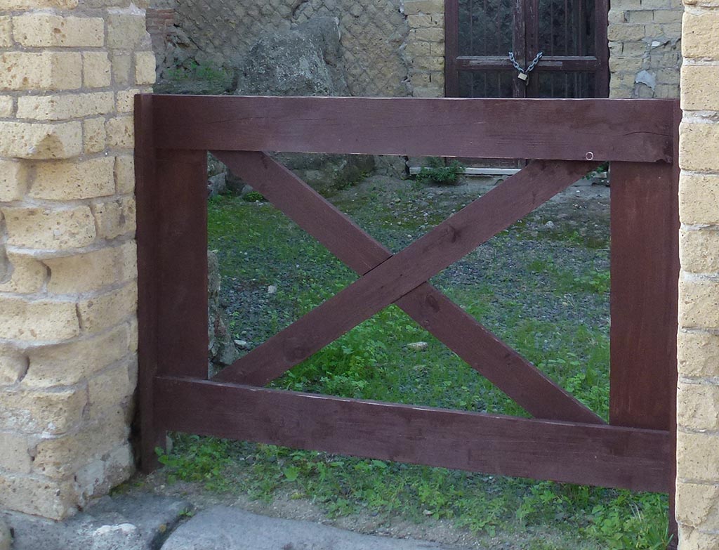 IV.19 Herculaneum. October 2012. Doorway of shop-room.
Behind the door pillar on the lower left of the photo would appear to be the podium of a family shrine, as described by Maiuri.
Photo courtesy of Michael Binns.