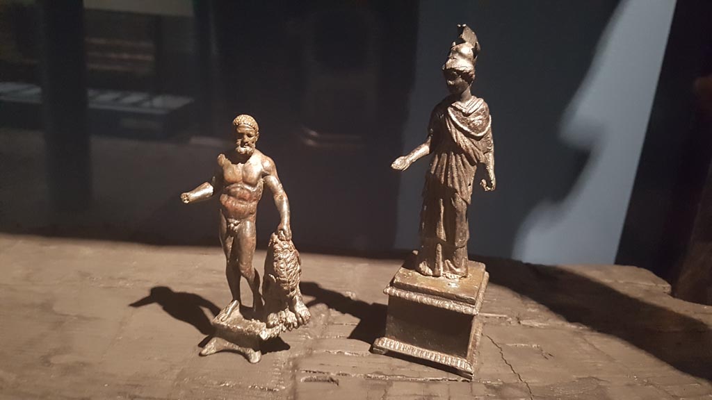 VI.13 Herculaneum. August 2023. Detail of figures typically found in a shrine. Photo courtesy of Maribel Velasco.
On display in exhibition entitled – “Materia. Il legno che non bruciò ad Ercolano”.