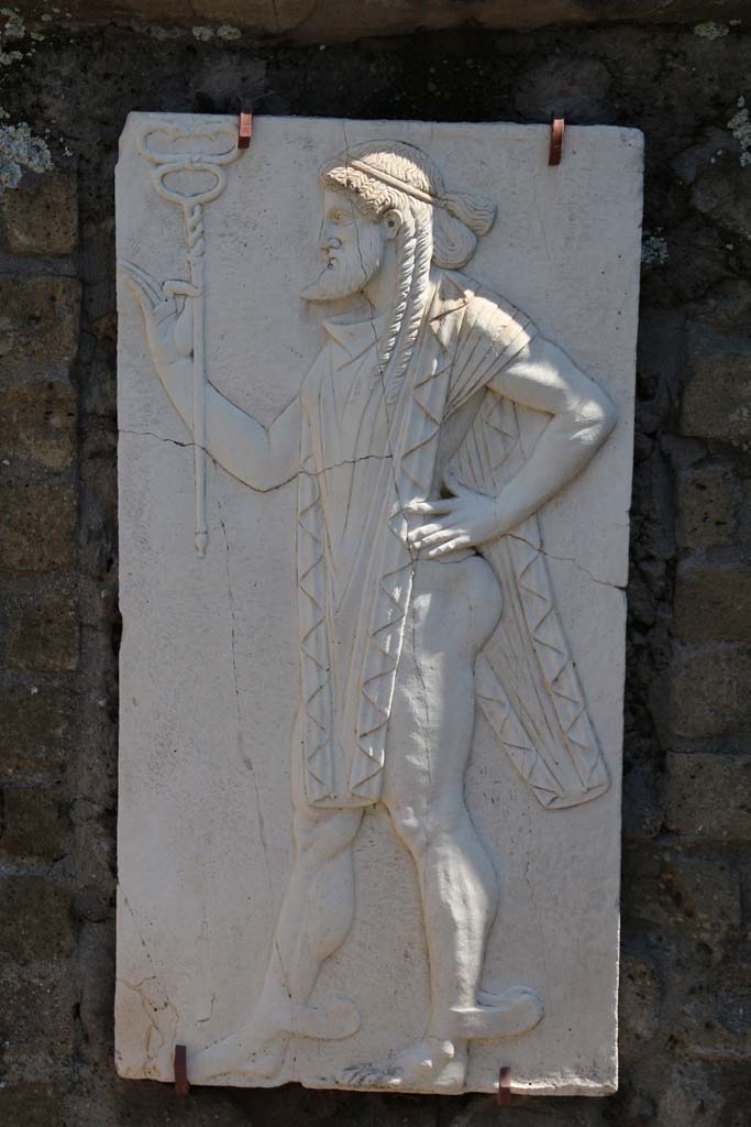 Herculaneum, April 2014. Sacred Area terrace, the shrine of Four Gods. Reproduction relief of Mercury.
Photo courtesy of Klaus Heese.