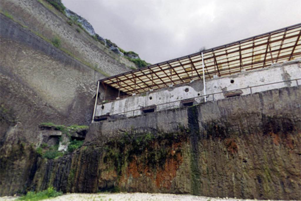 Villa dei Papiri, Herculaneum. 2004. The remains (left) of an apsidal/bow window on the second lower level.
The floor of first lower level of the basis villae is indicated by a string course on the façade of the Villa (height 24 cm; depth 26 cm), which suggests the presence of a further level. 
During the Infratecna Excavation (1996-8), a structure protruding in respect to the front of the basis villae was discovered at the west end of the façade. 
This apsidal or at least curvilinear avant-corps is marked by a series of large windows (1.75 m wide; 1.40 m high).
The avant-corps was therefore an imposing and airy 5.50 m high bow window structure. 
It was furnished with ten windows arranged on two levels, all of which were bolted at the time of the eruption. 
Inside the bay windows the space is still almost entirely filled up with volcanic material.
See Esposito D. and Guidobaldi M., 2010. New Archaeological Research at the Villa of the Papyri, in the Villa of the Papyri at Herculaneum. Berlin: De Gruyter, p. 41-2, fig. 32, notes 62-3. 
